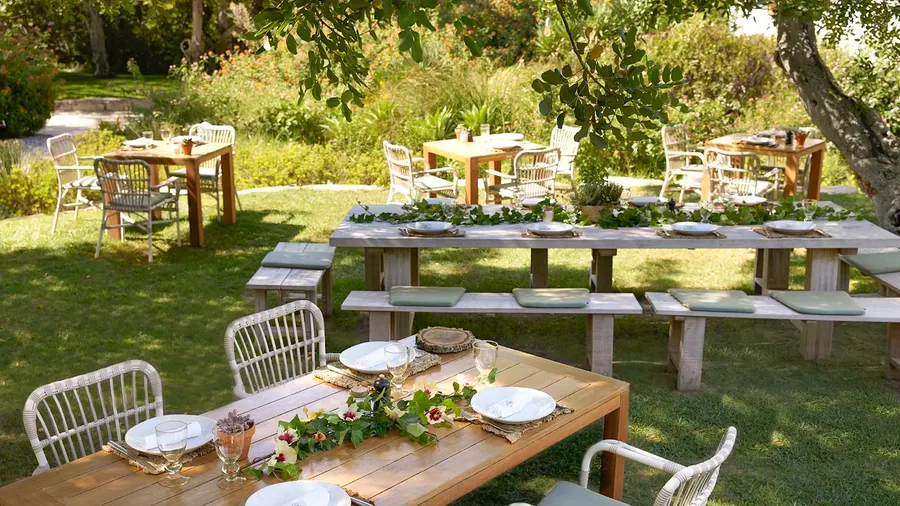 Gedekte eettafel buiten in een weelderige tuin